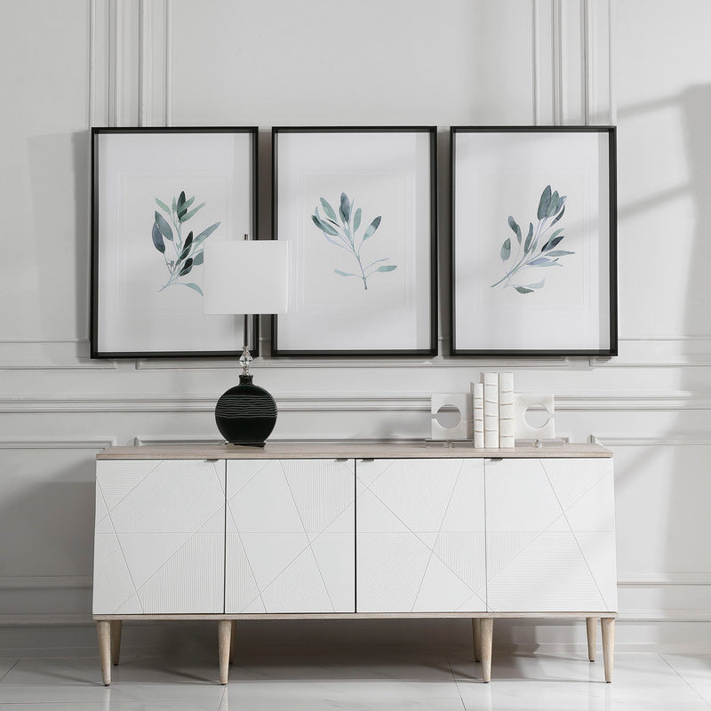 Set of three framed watercolor sage green prints by Uttermost, featuring simple botanical designs on white backgrounds.