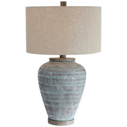 Uttermost Pelia table lamp in light aqua with a sleek, modern design and a cylindrical base on a neutral surface.