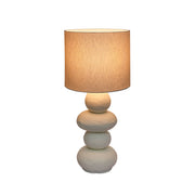 TOV Furniture Pebble Papier Mache Lamp, modern table lamp with textured, rounded pebble design and neutral finish on a wooden surface.