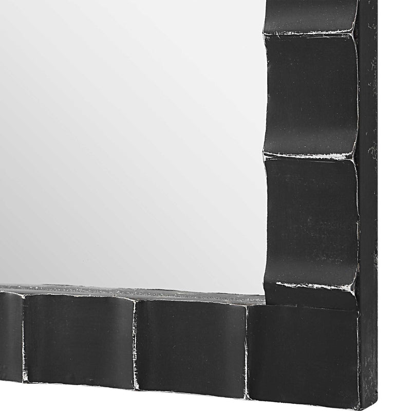 Black industrial wall mirror with a round metal frame, featuring a sleek black finish and modern design by Uttermost.