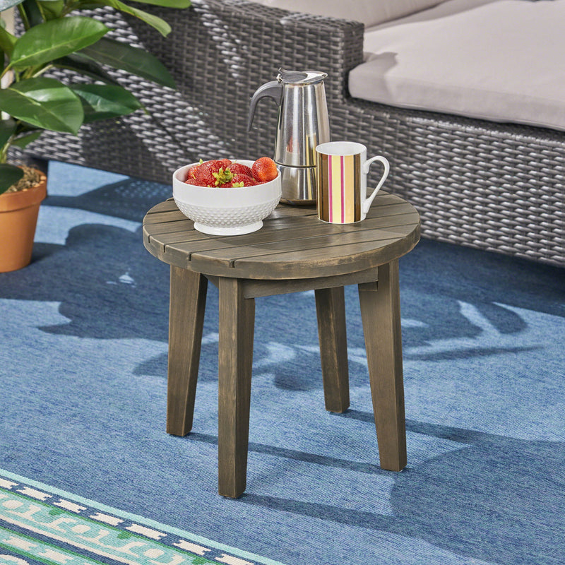 Noble House outdoor acacia wood side table with weather-resistant finish, featuring a sturdy rectangular design for outdoor use.