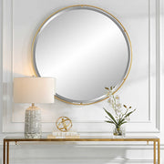 Round gold accent mirror by Uttermost with a sleek, modern frame, ideal for contemporary interior decor.