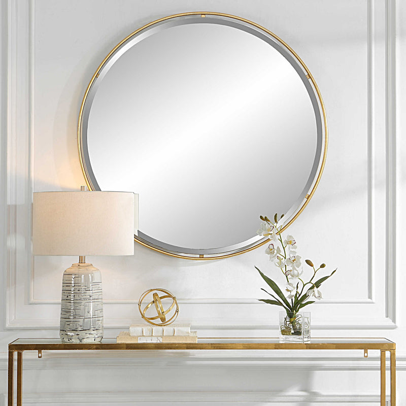 Round gold accent mirror by Uttermost with a sleek, modern frame, ideal for contemporary interior decor.